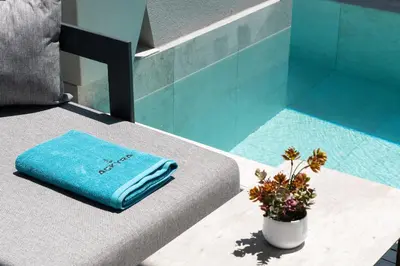 a blue towel sitting on a couch with a potted plant at Agkyra Hotel in Rhodes Town