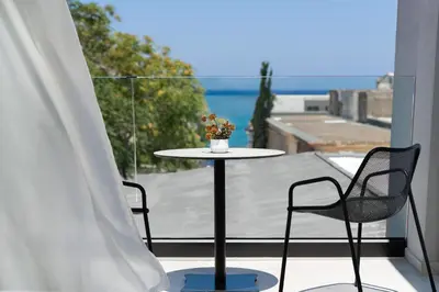 a table and two chairs on a balcony with a view at Agkyra Hotel in Rhodes Town