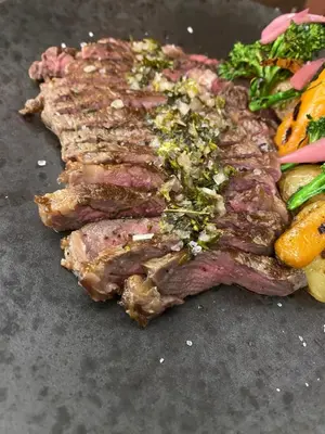 a piece of steak with vegetables on a table at Agkyra Hotel in Rhodes Town