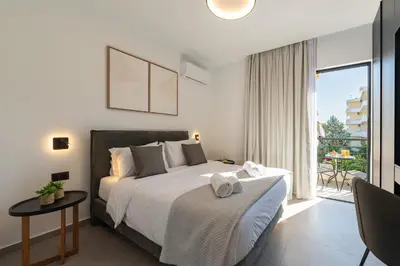 a bedroom with a large bed and a balcony at Rodos Downtown 107 in Rhodes Town