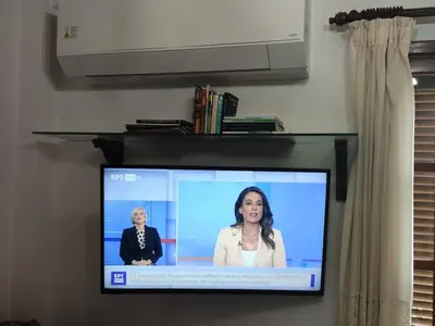 a flat screen tv with a woman on it at Kolymbia home in Kolimbia