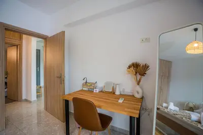 a room with a wooden table and a chair at Arokaria Seaview House in Koskinou