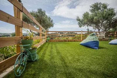 a yard with a fence and a bike on the grass at Arokaria Seaview House in Koskinou