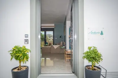 a hallway with two potted plants and a living room at Arokaria Seaview House in Koskinou