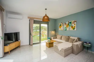 a living room with a couch and a tv at Arokaria Seaview House in Koskinou