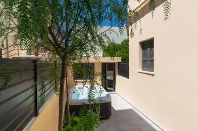 a bathtub in the courtyard of a house with a tree at Kyma Luxury Apartment in Rhodes Town