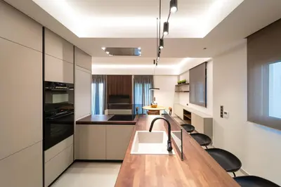 a kitchen with a long wooden table and black chairs at Kyma Luxury Apartment in Rhodes Town
