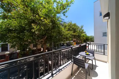 a balcony with a table and chairs and trees at Kyma Luxury Apartment in Rhodes Town