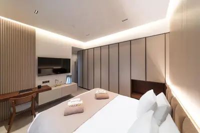 a bedroom with a bed and a desk and a television at Kyma Luxury Apartment in Rhodes Town