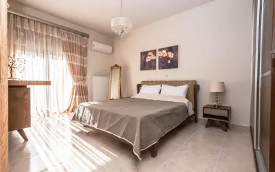 a bedroom with a bed and a large window at Xristina Home in Afantou