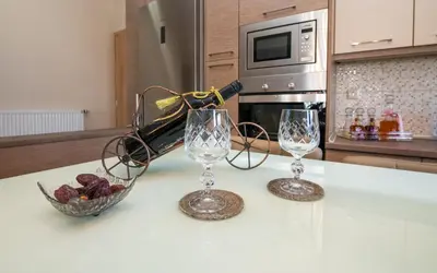 two wine glasses and a bowl of grapes on a kitchen counter at Xristina Home in Afantou