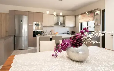 a kitchen with a table with purple flowers in a vase at Xristina Home in Afantou