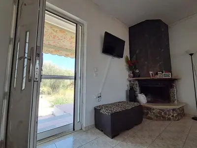 a living room with a fireplace and a television at Galinis Rooms in Paradeísion