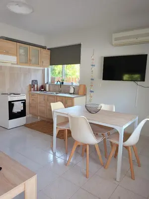 a kitchen with a table and chairs and a kitchen with a sink at comfy cozy rodini in Asgourou