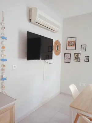 a living room with a flat screen tv on the wall at comfy cozy rodini in Asgourou