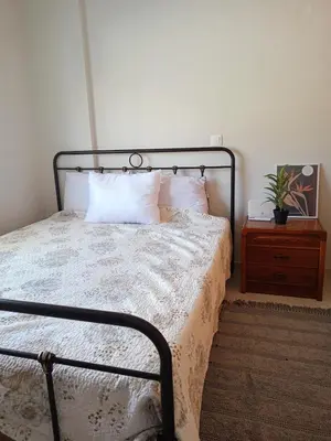 a bedroom with a bed and a table with a plant at comfy cozy rodini in Asgourou