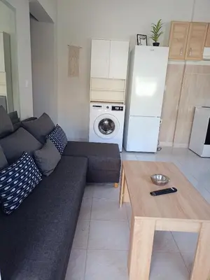 a living room with a couch and a refrigerator at comfy cozy rodini in Asgourou