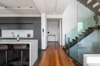 a kitchen with glass walls and a kitchen island with stools at Sunset Villa Rhodes in Ixia