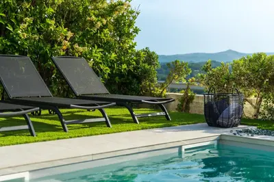 two chairs sitting next to a swimming pool at Sunset Villa Rhodes in Ixia