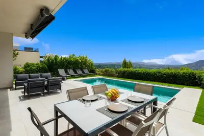 a patio with a table and chairs and a swimming pool at Sunset Villa Rhodes in Ixia