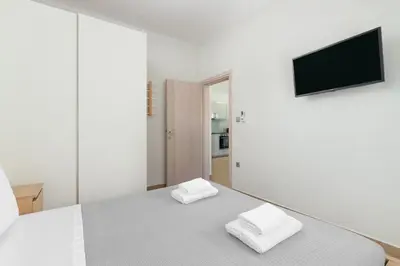 a white bedroom with a bed with two white towels at Irene Gem in Rhodes Town