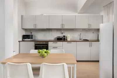 a kitchen with a wooden table and white cabinets at Irene Gem in Rhodes Town