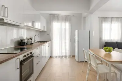 a kitchen with a table and a white refrigerator at Irene Gem in Rhodes Town