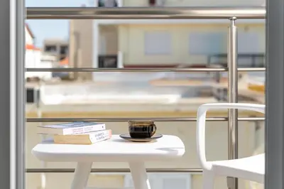 a cup of coffee sitting on a table next to a chair at Irene Gem in Rhodes Town