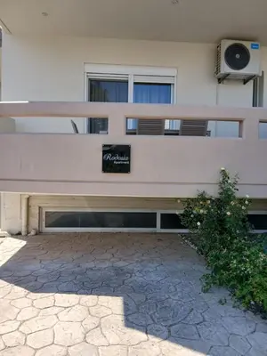 a bench in front of a building with a sign on it at Rodosia Apartment IN Rhodes in Rhodes Town