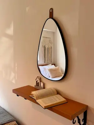 a mirror on a wall with a book on a shelf at Rodosia Apartment IN Rhodes in Rhodes Town