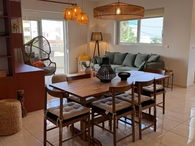 a living room with a wooden table and chairs at Rodosia Apartment IN Rhodes in Rhodes Town