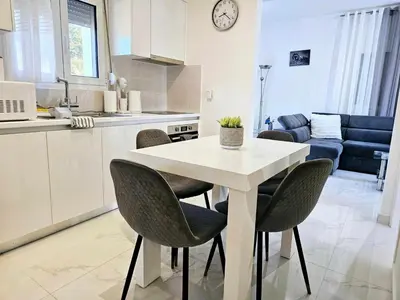 a kitchen with a white table and chairs in a room at Dream Luxury Suites & Apartment Pastida in Pastida