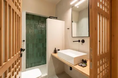 a bathroom with a sink and a mirror at House Marigo Suites in Koskinou