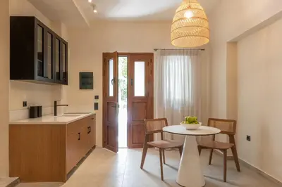 a kitchen with a table and some chairs and a table at House Marigo Suites in Koskinou