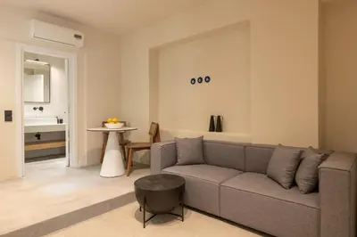 a living room with a couch and a table at House Marigo Suites in Koskinou