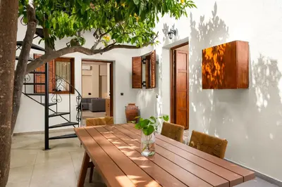 a wooden table in a room with a tree at House Marigo Suites in Koskinou
