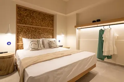 a bedroom with a large bed and a closet at House Marigo Suites in Koskinou