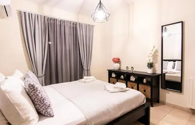 a bedroom with a white bed and a mirror at Serenity Escape in Nísos Ródos