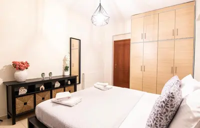 a bedroom with a large white bed and a mirror at Serenity Escape in Nísos Ródos