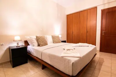 a bedroom with a large bed with a wooden cabinet at Serenity Escape in Nísos Ródos