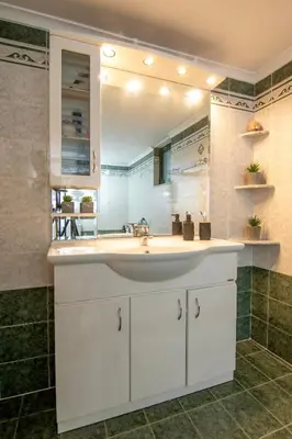 a bathroom with a white sink and a mirror at Serenity Escape in Nísos Ródos