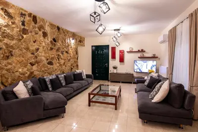 a living room with couches and a stone wall at Serenity Escape in Nísos Ródos