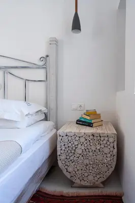 a bedroom with a bed and a table with books at Peaceful Lindos in Líndos