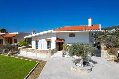 a white house with a red roof at Yannis Place in Rhodes Town