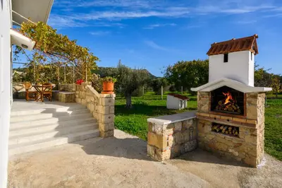 an outdoor fireplace with a table and a patio at Yannis Place in Rhodes Town