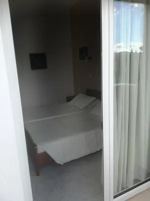 a small bedroom with a bed and a window at Hotel Dimitra Sun in Archangelos