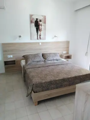 a bedroom with a bed and a picture on the wall at Hotel Dimitra Sun in Archangelos