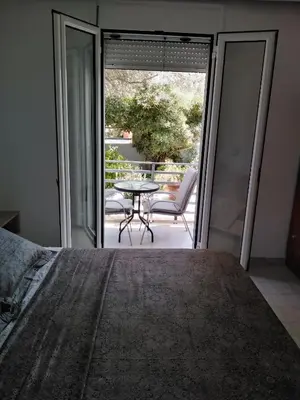 a bedroom with a bed and a table and a patio at Hotel Dimitra Sun in Archangelos