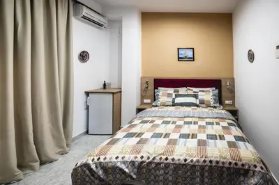 a bedroom with a large bed and a curtain at Hotel Dimitra Sun in Archangelos