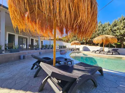 a patio with a table and umbrella and a pool at Dream Luxury Apartment Suites in Pastida